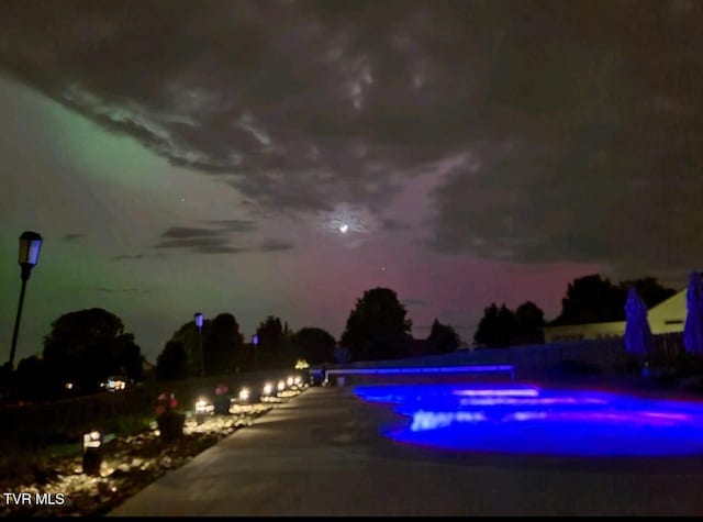 view of pool at twilight