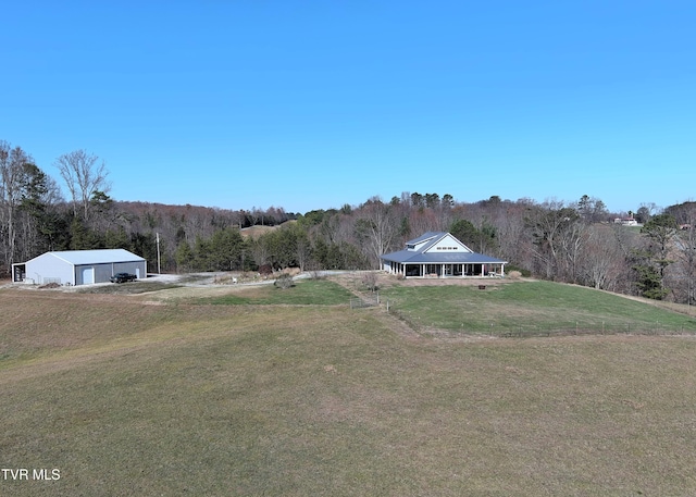 view of yard featuring a detached garage and a wooded view