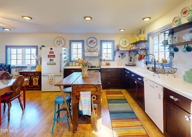 kitchen featuring a wealth of natural light, white appliances, a sink, and open shelves