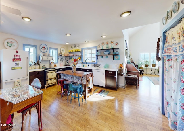 kitchen with a healthy amount of sunlight, white appliances, open shelves, and light countertops