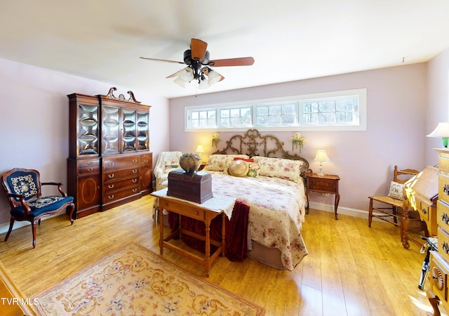 bedroom with ceiling fan, baseboards, and hardwood / wood-style flooring