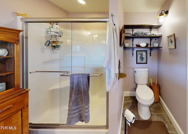 bathroom with a stall shower, baseboards, and toilet