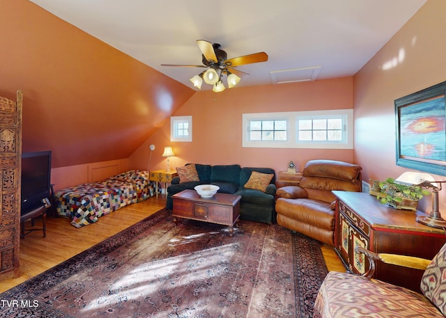 bedroom with lofted ceiling, wood finished floors, attic access, and a ceiling fan