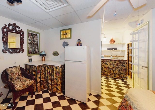 bar featuring a paneled ceiling, freestanding refrigerator, and tile patterned floors