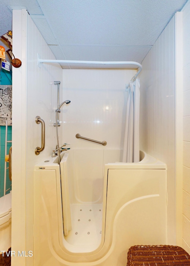 bathroom with a textured ceiling and a shower with shower curtain