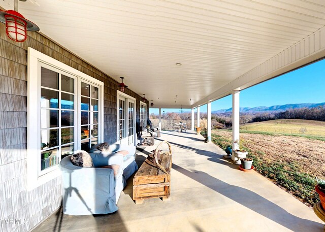 view of patio with a mountain view and french doors