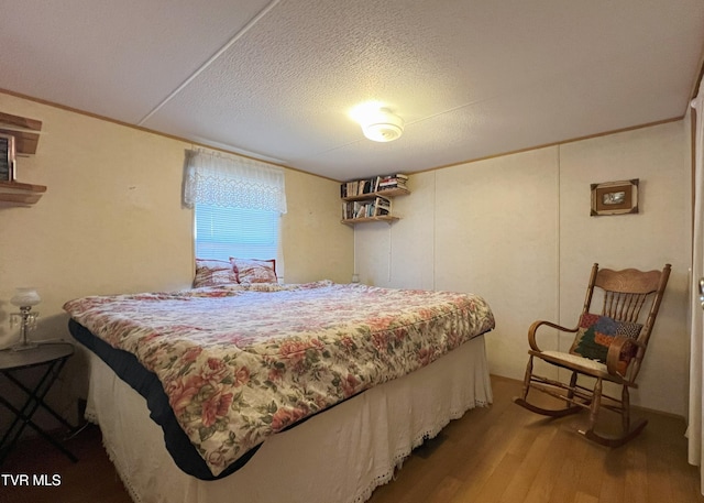 bedroom featuring a textured ceiling and wood finished floors