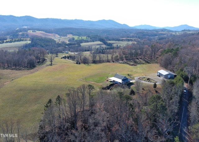 birds eye view of property featuring a mountain view, a view of trees, and a rural view