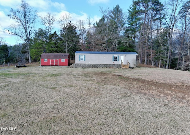 manufactured / mobile home featuring an outbuilding, metal roof, a storage shed, and a front yard