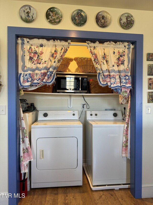 washroom featuring laundry area, wood finished floors, and independent washer and dryer