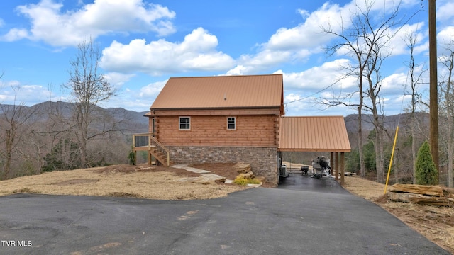 view of home's exterior with a mountain view and a carport