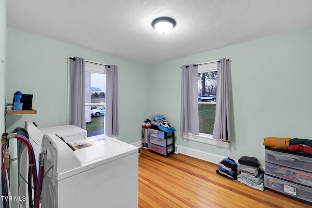 laundry room featuring washing machine and dryer, a wealth of natural light, and wood-type flooring