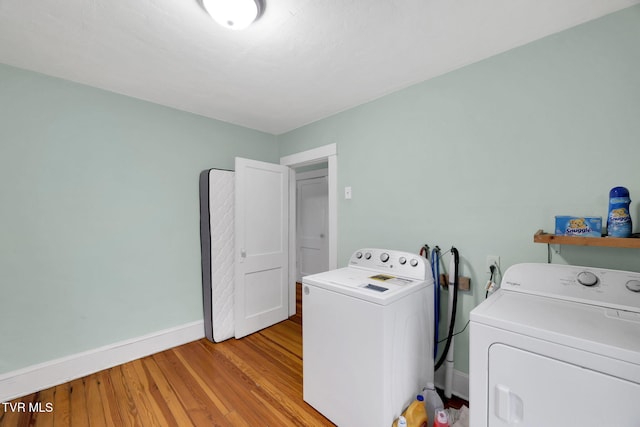 washroom with washing machine and dryer and light wood-type flooring