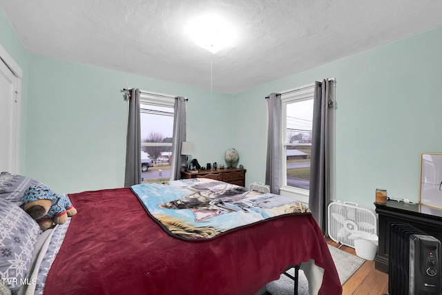 bedroom with a textured ceiling and light wood-type flooring