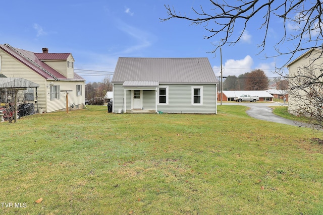 rear view of house featuring a lawn