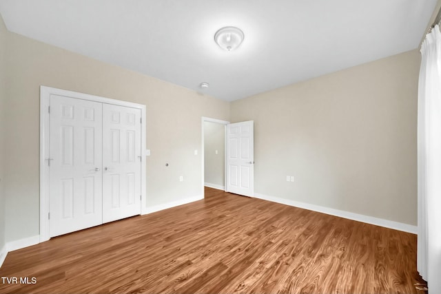 unfurnished bedroom with hardwood / wood-style floors and a closet