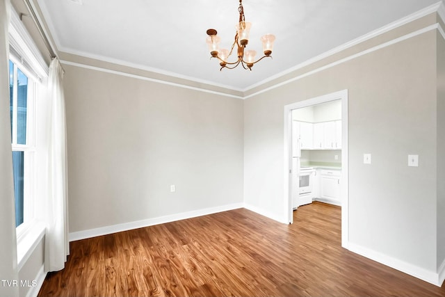 empty room featuring crown molding, wood-type flooring, and a notable chandelier