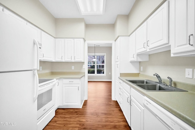 kitchen featuring white appliances, dark wood-type flooring, sink, decorative light fixtures, and white cabinetry