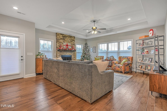 living room featuring a tray ceiling, ceiling fan, and dark wood-type flooring