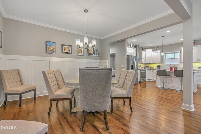 dining area featuring hardwood / wood-style floors, crown molding, and a chandelier