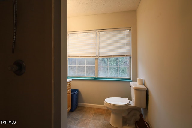 bathroom featuring vanity, a textured ceiling, and toilet