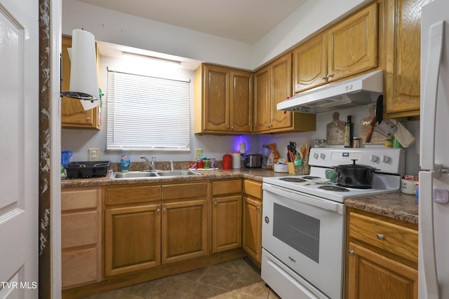 kitchen featuring sink, dark tile patterned flooring, and white appliances