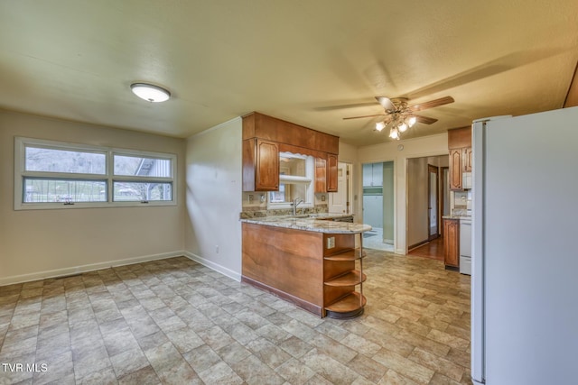 kitchen featuring ceiling fan, sink, white appliances, and kitchen peninsula