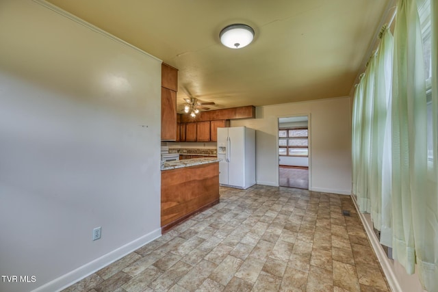 kitchen featuring ceiling fan and white refrigerator with ice dispenser