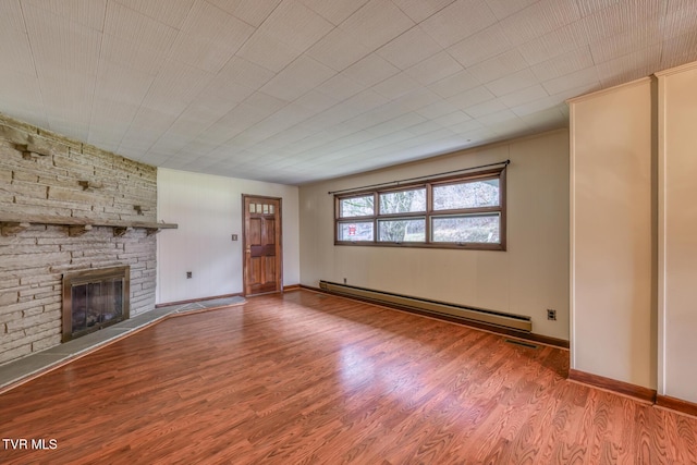 unfurnished living room featuring wood-type flooring, a fireplace, and a baseboard radiator