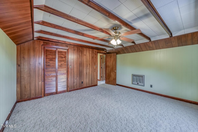 interior space with ceiling fan, wooden walls, light colored carpet, and lofted ceiling