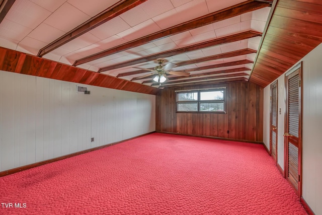 interior space featuring vaulted ceiling with beams, ceiling fan, and wooden walls