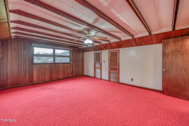 spare room with ceiling fan, wood walls, and beam ceiling