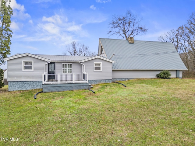 back of property with a wooden deck and a yard