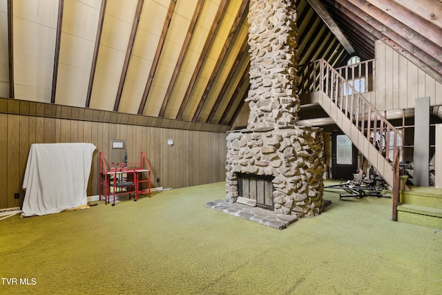 interior space with carpet flooring, high vaulted ceiling, and wood walls