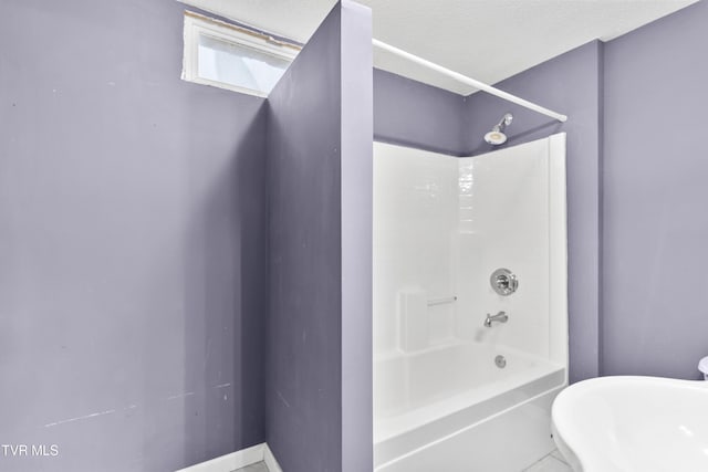 bathroom with a textured ceiling and  shower combination