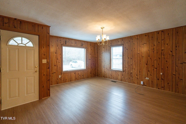 entrance foyer featuring a chandelier, hardwood / wood-style floors, and a healthy amount of sunlight