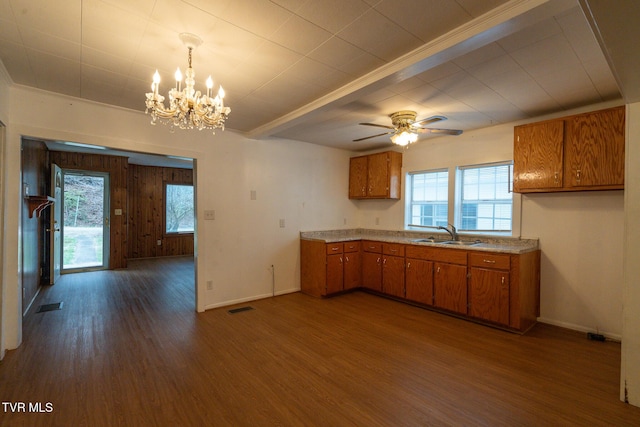 kitchen with ceiling fan with notable chandelier, sink, decorative light fixtures, and dark wood-type flooring