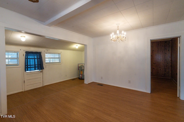 unfurnished room featuring beam ceiling, gas water heater, an inviting chandelier, and hardwood / wood-style flooring