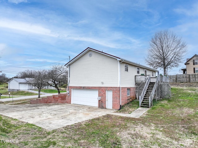 view of property exterior featuring a wooden deck, a yard, and a garage