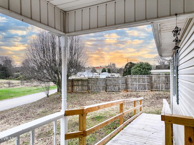 yard at dusk featuring a wooden deck