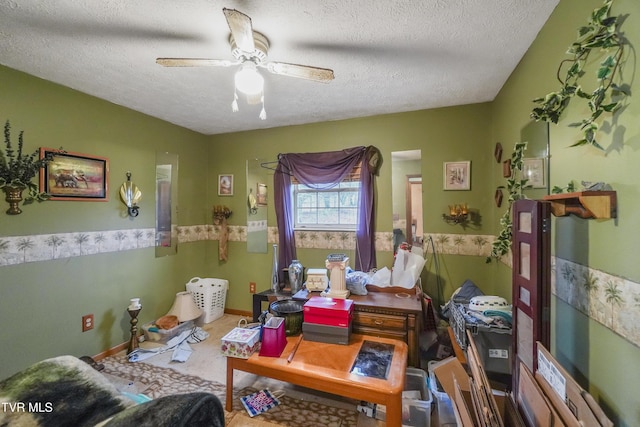 miscellaneous room with ceiling fan and a textured ceiling