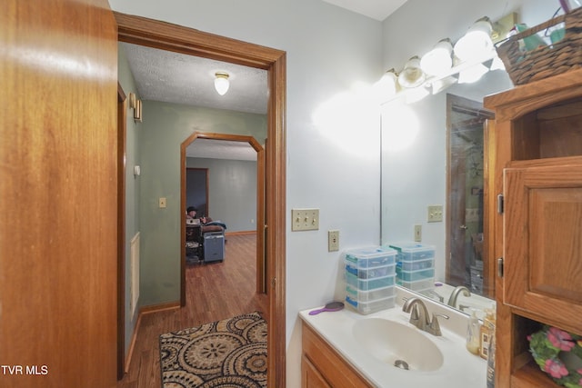 bathroom featuring vanity, wood-type flooring, and a textured ceiling