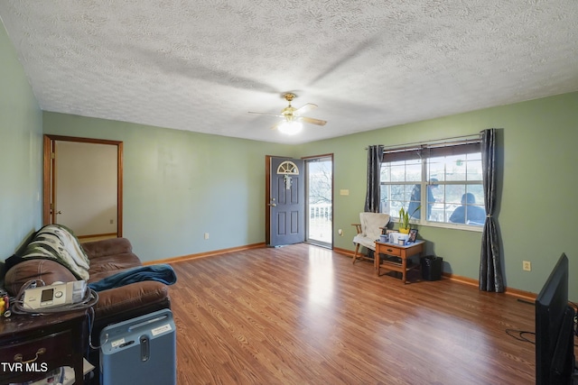 foyer with wood-type flooring, a textured ceiling, and ceiling fan