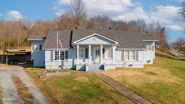 view of front facade with a carport, a porch, and a front lawn