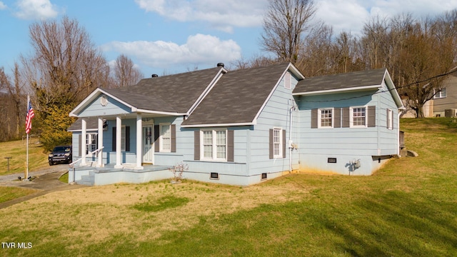 back of property with a shingled roof, crawl space, covered porch, and a lawn