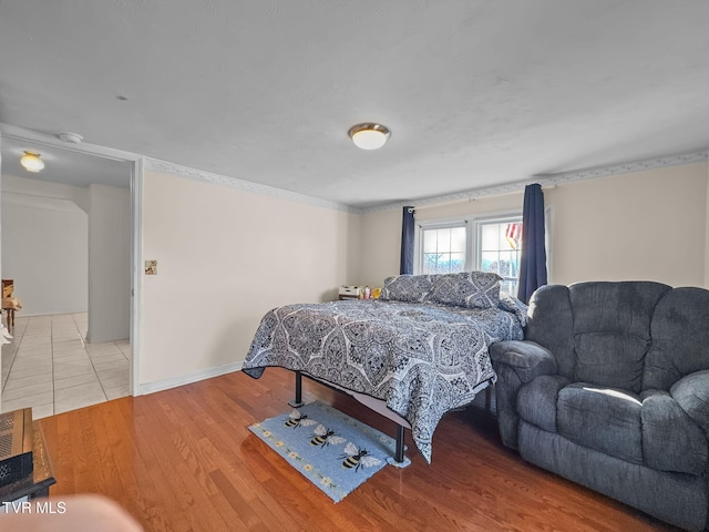 bedroom with baseboards and wood finished floors