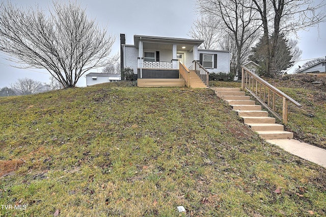 view of front facade with covered porch and a front yard