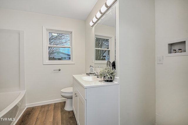 bathroom featuring vanity, toilet, wood-type flooring, and a tub