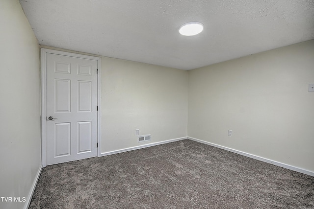 unfurnished room with dark carpet and a textured ceiling