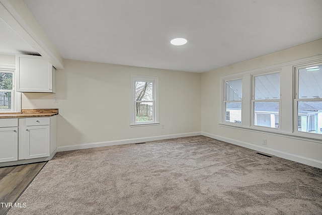 unfurnished dining area featuring light carpet